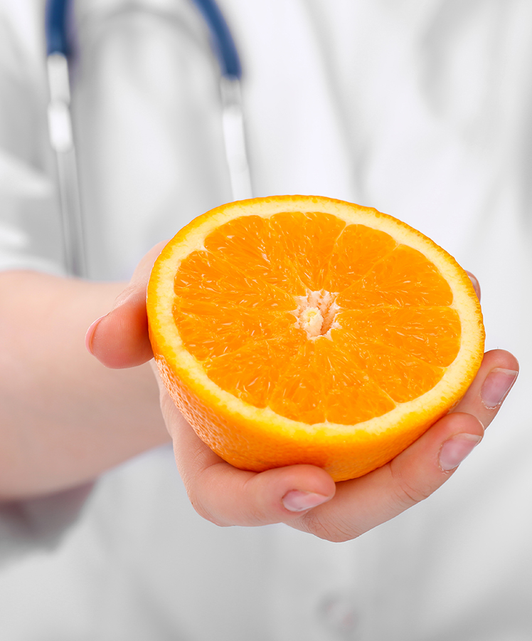 Nutritionist doctor with orange, closeup, vitamin C