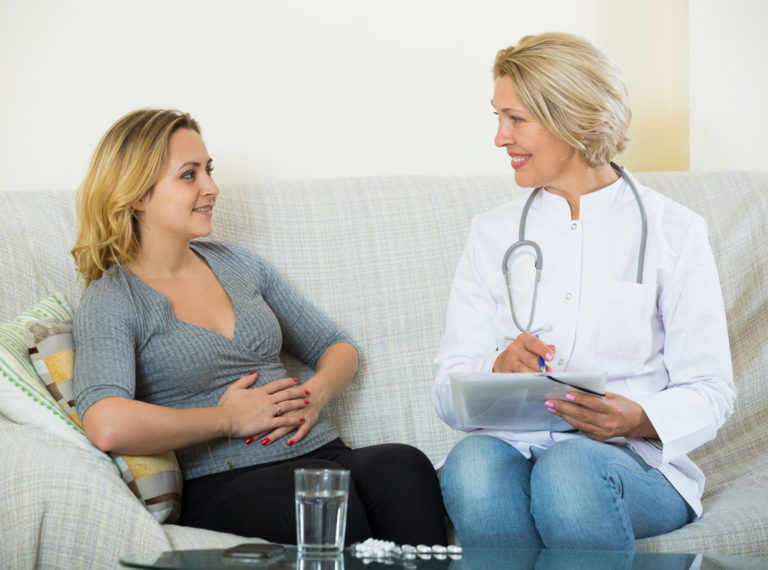 A patient sits on a couch with a naturopathic doctor discussing gut health