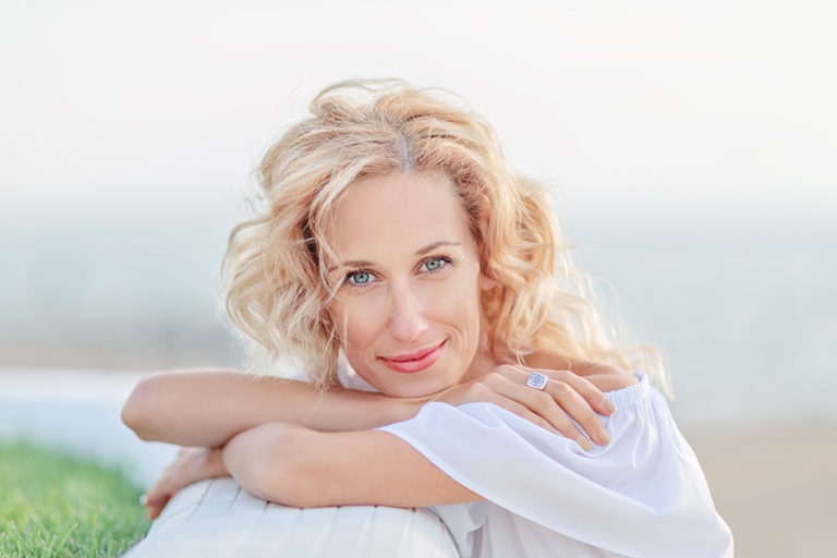 A woman in the period of menopause/ Blond mature woman against the sky and grass background